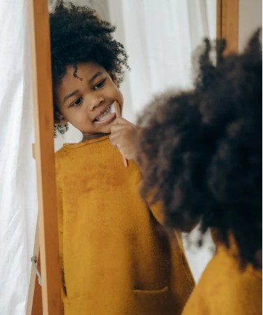 ребенок чистит зубы перед зеркалом